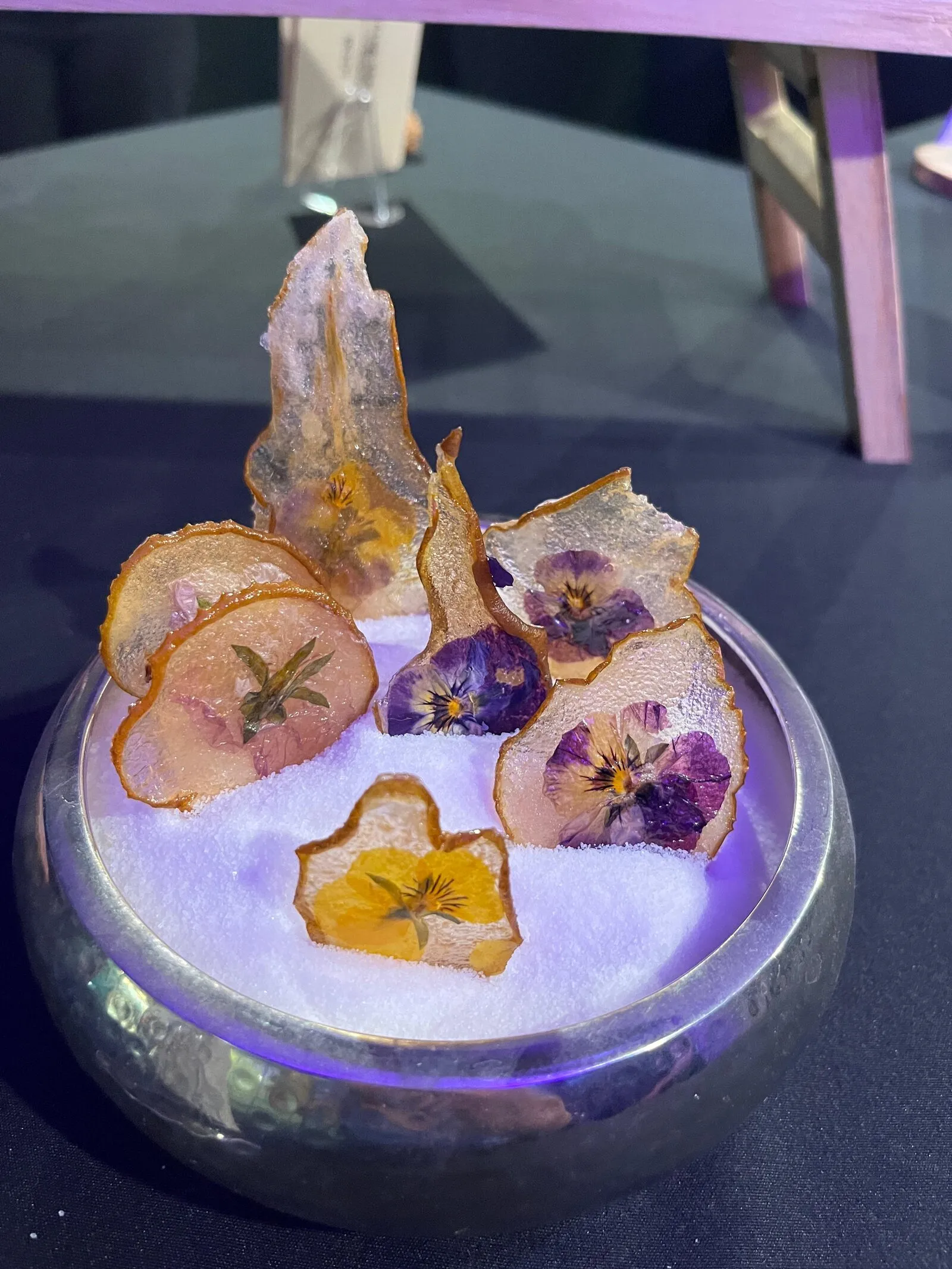A ritual plate of dried citrus and pressed flowers under a glass dome