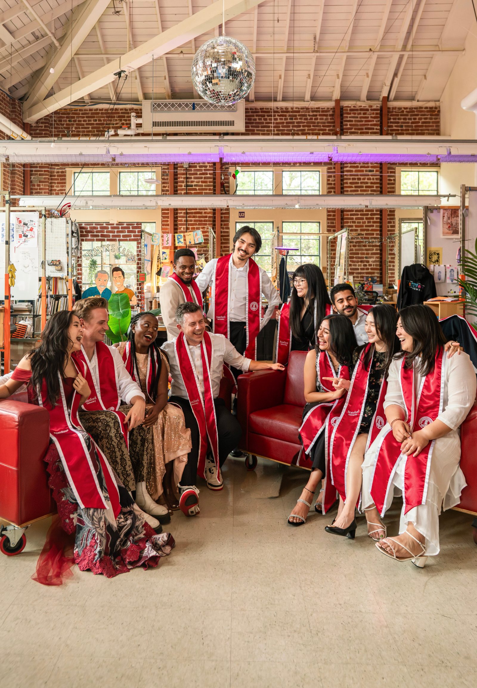 The Dabble collective in Stanford graduation sashes, laughing together in the d.school loft